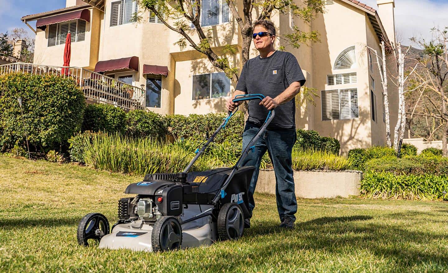 Akumulator kosiarki elektrycznej ładowany w garażu na ładowarce