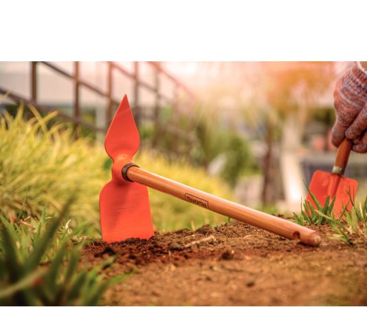 Motyka do pielenia chwastów: jakie rodzaje i kształty sprawdzą się w Twoim ogrodzie? ogrodnik w słomianym kapeluszu pielący chwasty motyką w warzywniku